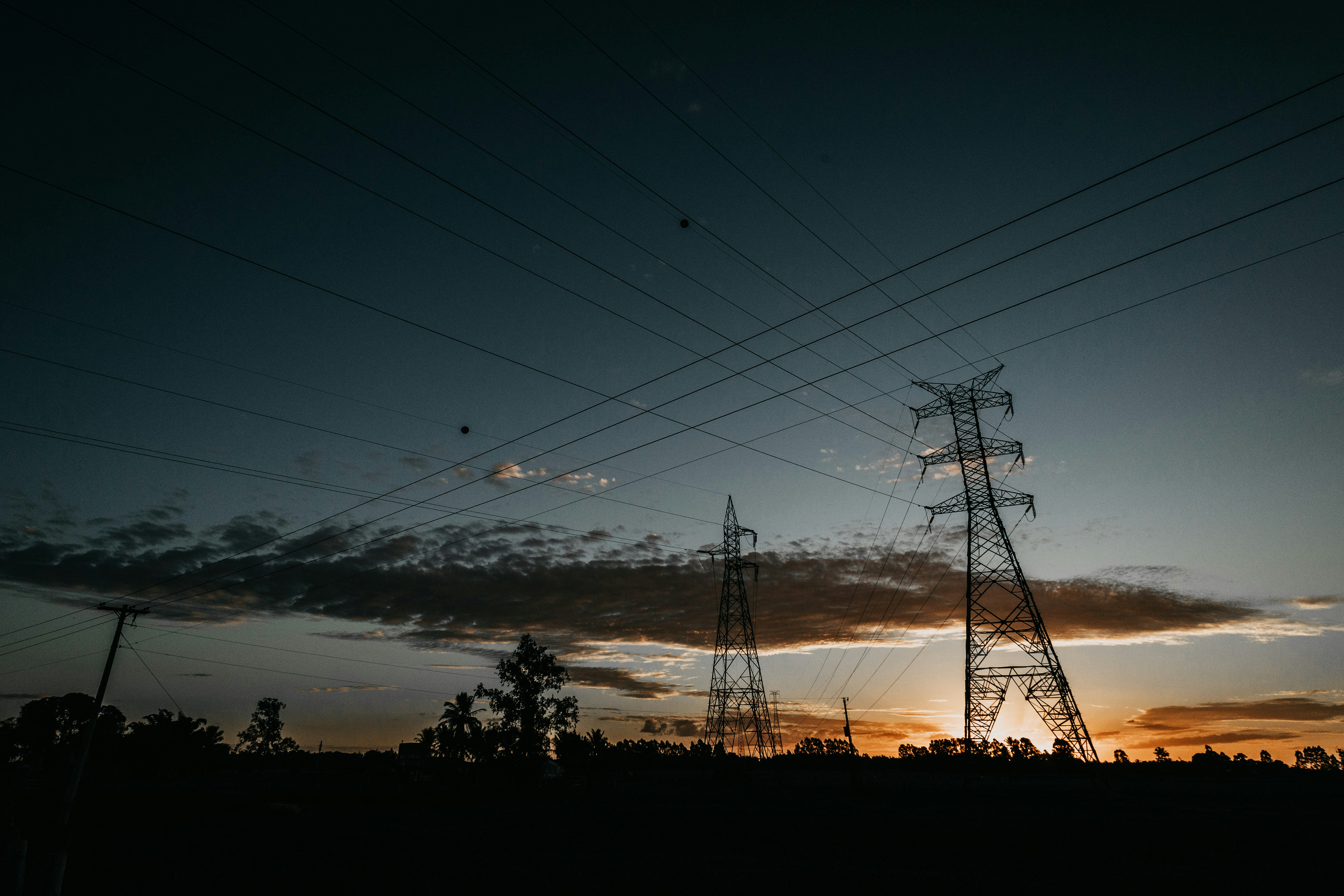 low-angle photography of transmission towers during golden hour